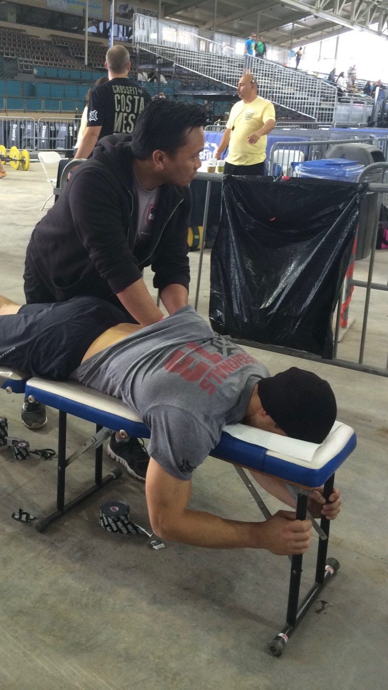 Dr. Ken Ycmat performing soft-tissue work on an athlete at a CrossFit competition